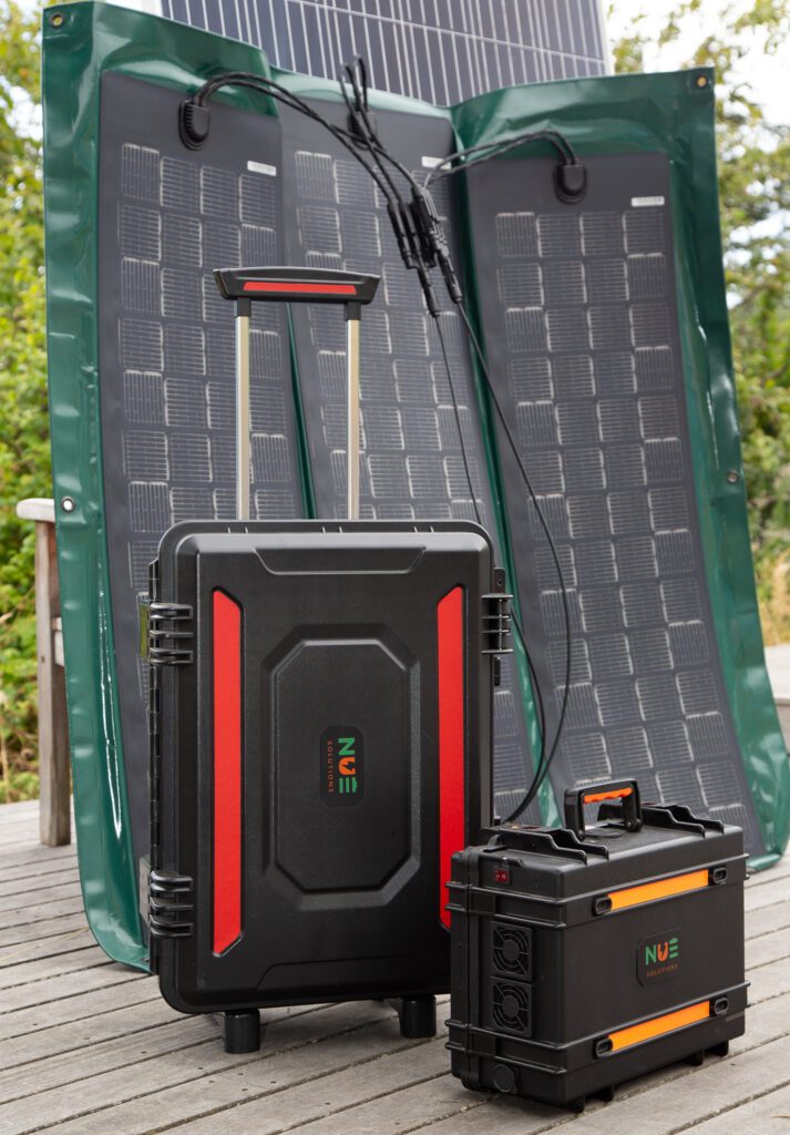 Two portable power stations in hard suitcases stand in front of a foldable, flexible solar panel.