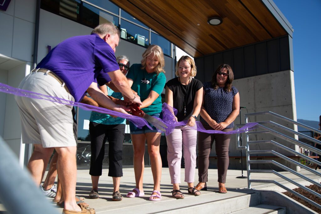 Nooksack Valley School District board members and administrators cut the bright purple ribbon.