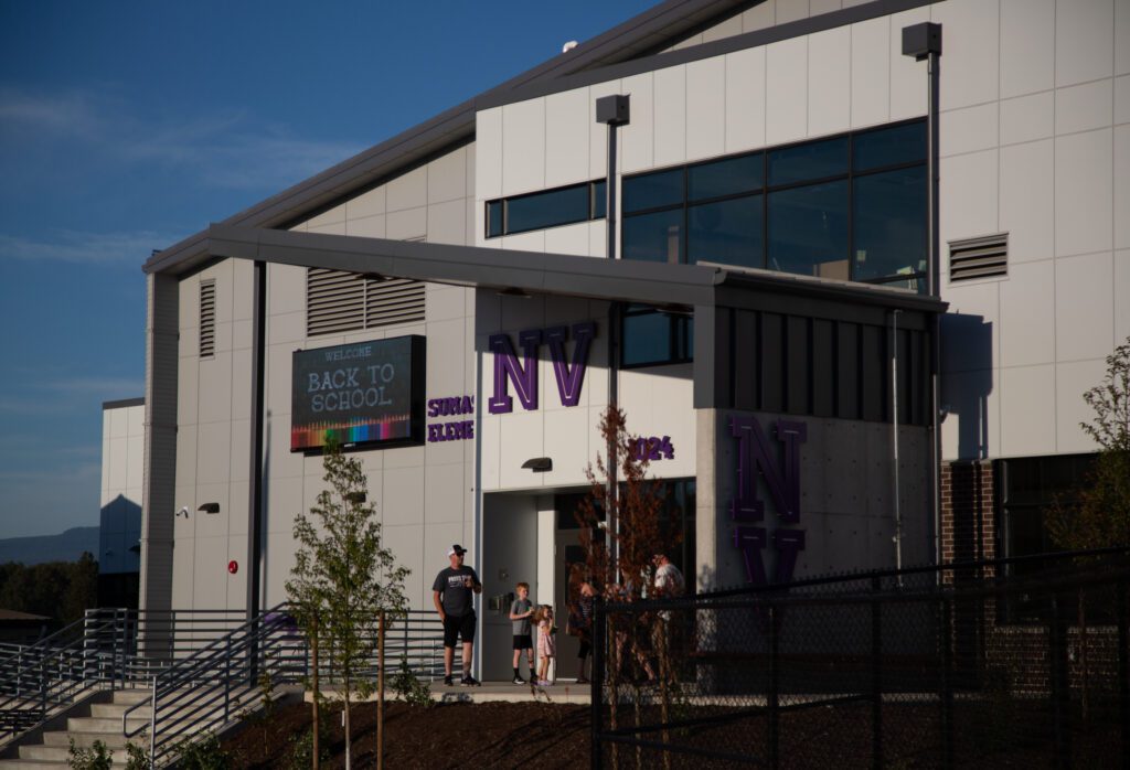 Parents and children filter out the main doors of the new Sumas Elementary School.