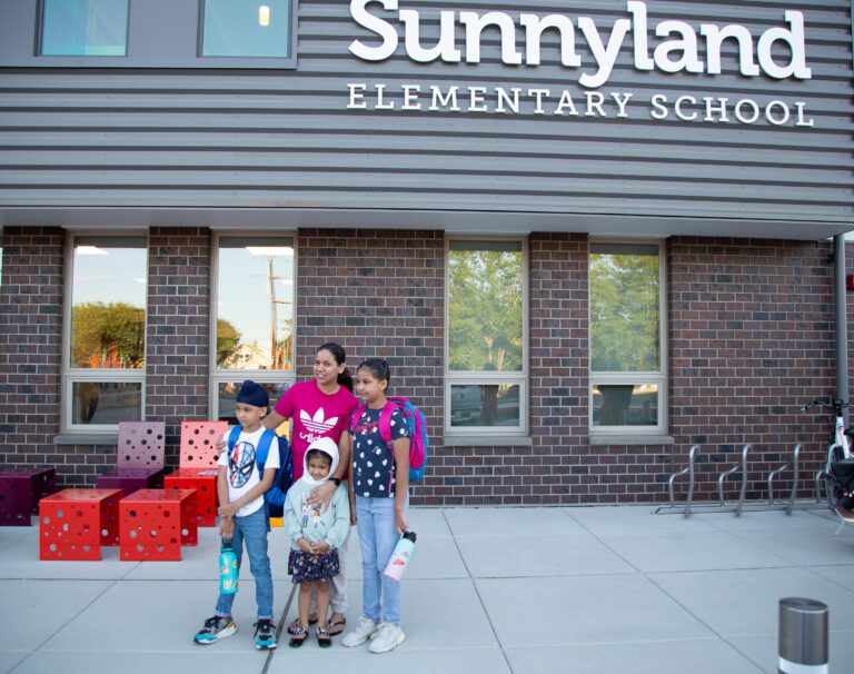 Satinder Kaur, center, takes a photo with her kids Ajai, left, and Ganeev, right, on their first day.