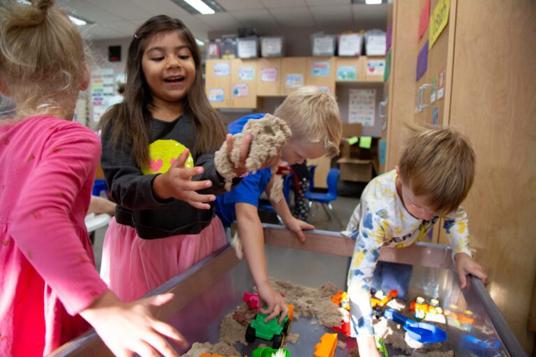 Kindergarteners play with kinetic sand at Northern Heights Elementary with other beach toys.