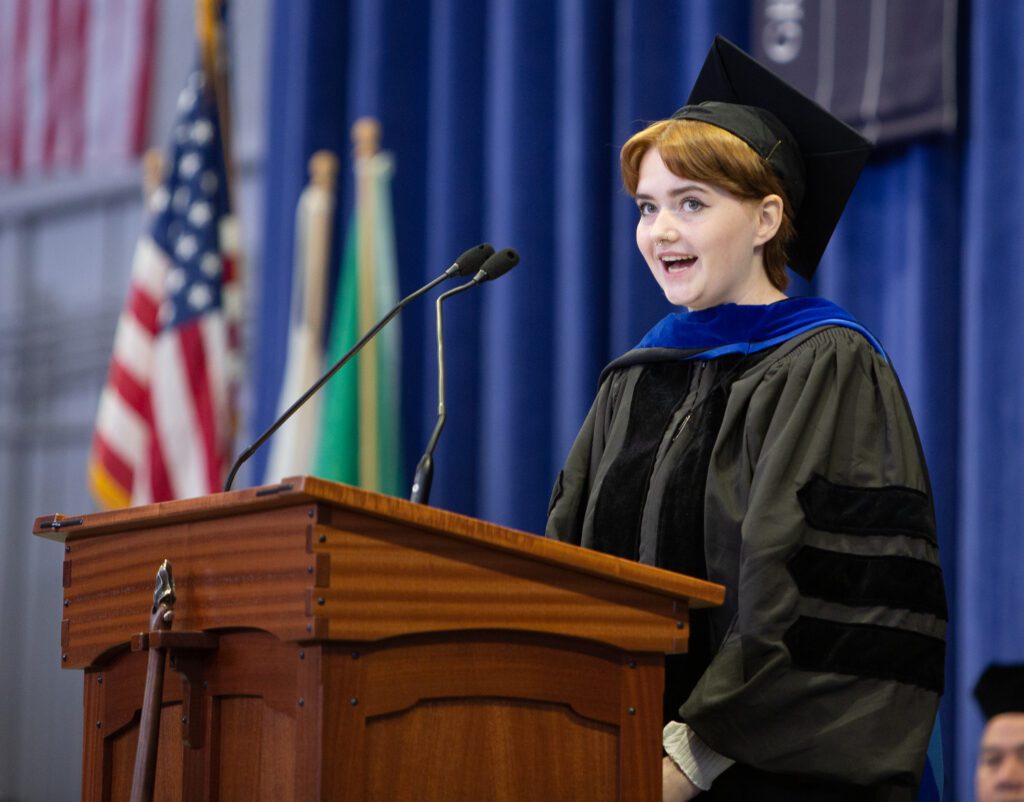 Student Trustee Keara Ryan speaks from behind the podium, addressing the new students.