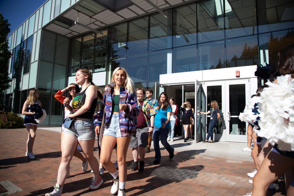 New students depart Carver Gym as they are cheered on by cheerleaders.