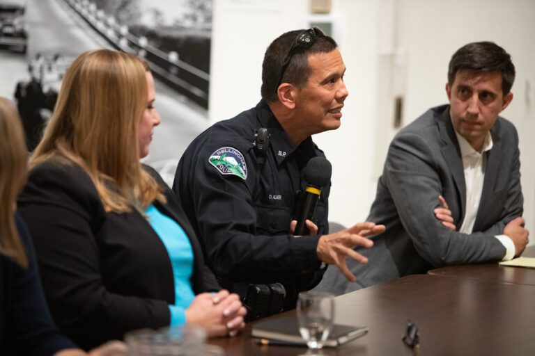 Chief Don Almer talks as he gestures with his hand inbetween two representatives.