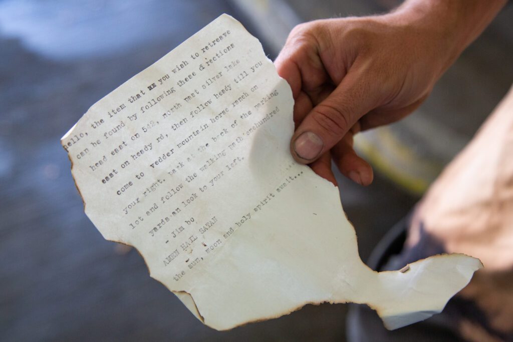 Alec Howard holds a singed note with typed instructions to find the lost door.