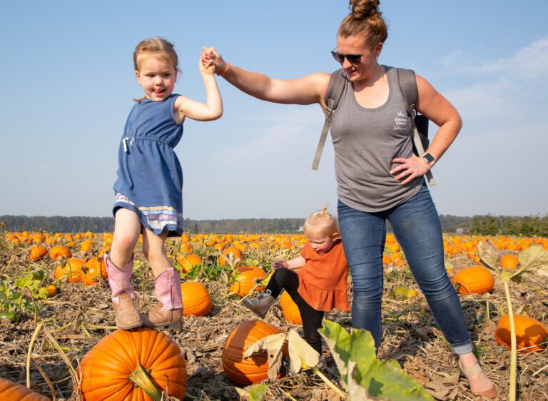 From left, Maddy Vandervliet, RaeLynn DeBruin and Allie DeBruin play amongst the pumpkin patch.