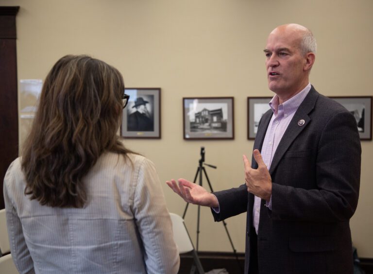 U.S. Rep. Rick Larsen speaks with an audience member as he gestures with both hands.