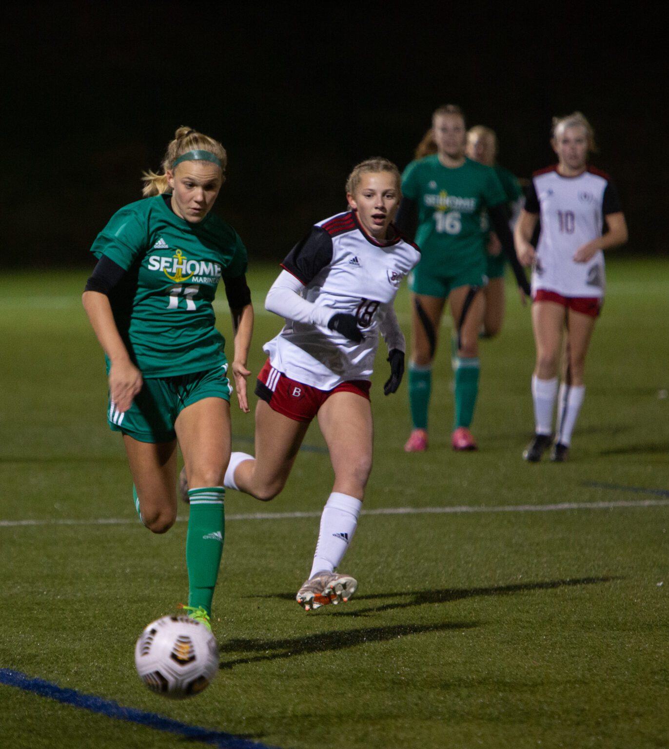 Sehome forward Ryan Boehm, left, and Bellingham defender Kira Carlson chase the ball down the field.