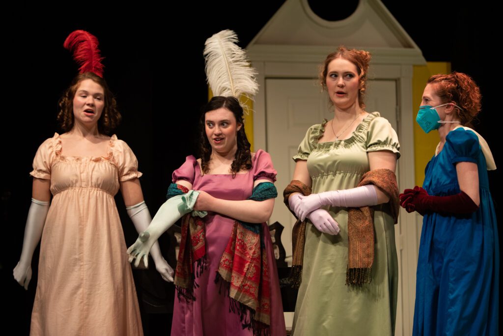 From left, Lydia Bennet (Cecilia Nielsen), Elizabeth Bennet (Hannah Cafarella), Jane Bennet (Molly Garrison) and Mrs. Bennet (Cordelia Cloke) prepare for a ball while dressed in Victorian-themed costumes.