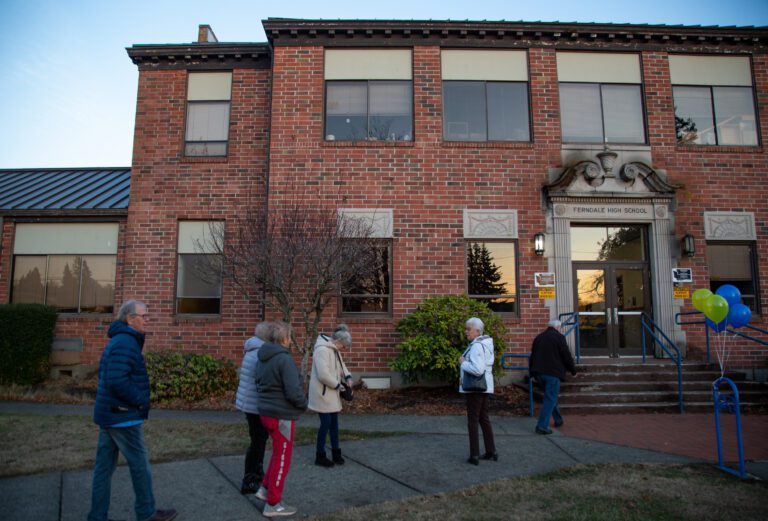 Members of the Ferndale High School Class of 1965 walk into Old Main as they greet other attendees at the entrance.