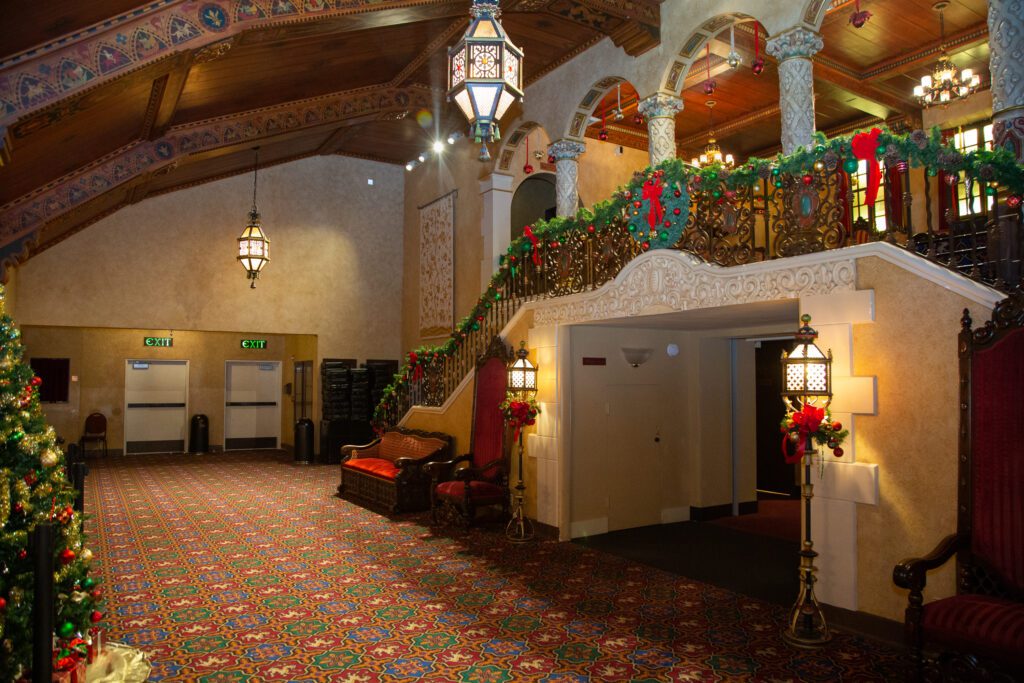 The Mount Baker Theatre's lobby decorated with Christmas decorations like holly, ornaments, and wreaths.