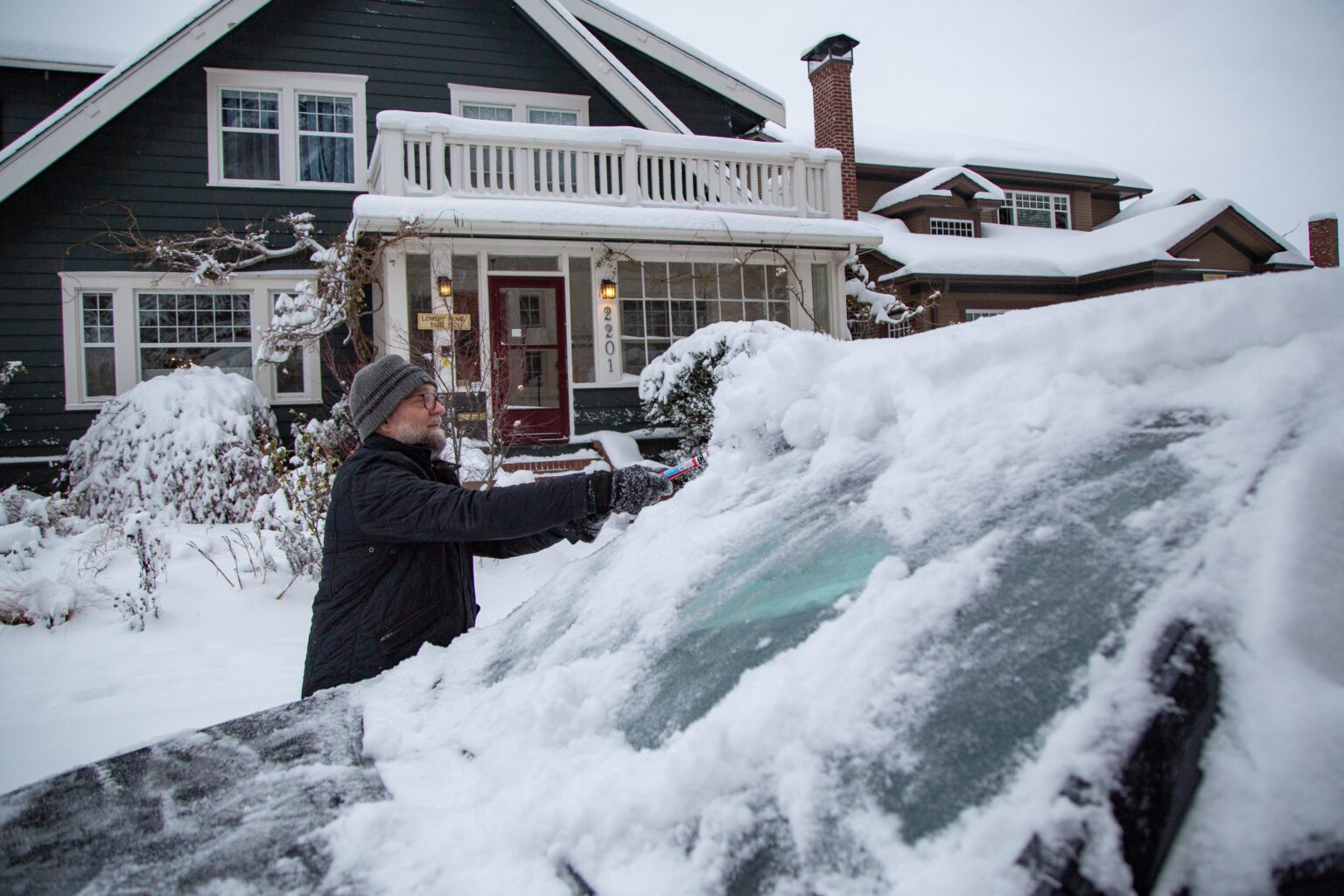 Andy Forrest wipes snow off his windshield.