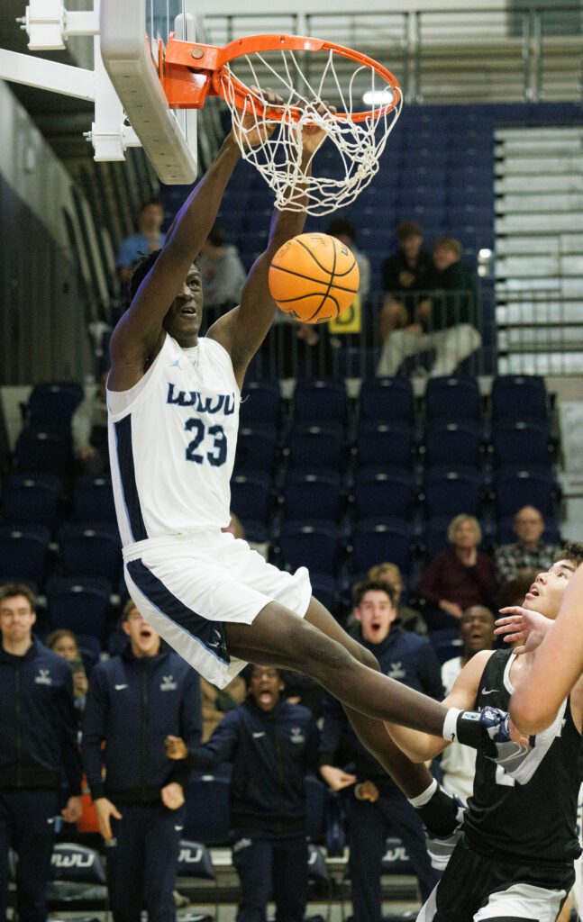 Western Washington University’s BJ Kolly throws down a hard slam dunk as attendees from the sidelines react in surprise.