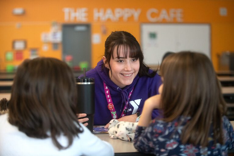 Lexi Belinskia, a program assistant at Whatcom Family YMCA, sits and talks with children during an after-school program.