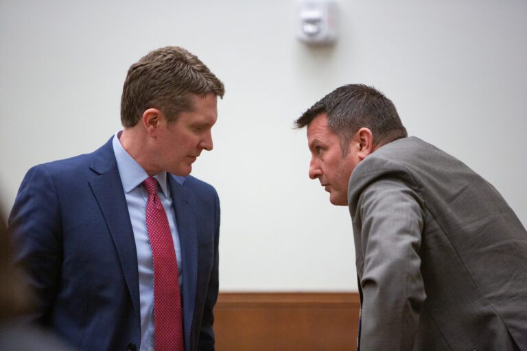 Attorney Shane Brady, left, and District Court Judge Jonathan Rands speak to one another closely.