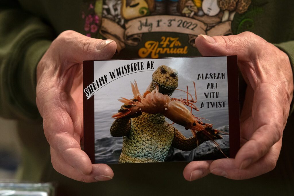 Al Laudert, founder of Shrimp Whisperer AK, shows off his first shrimp photograph, which depicts a Godzilla action figure devouring an Alaskan shrimp.