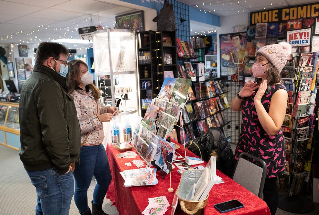 Max Dunstone, left, and Kaileigh Hubbard talk with Aireekah Laudert during the pop-up sale while hoilding one of the many gift cards on display.