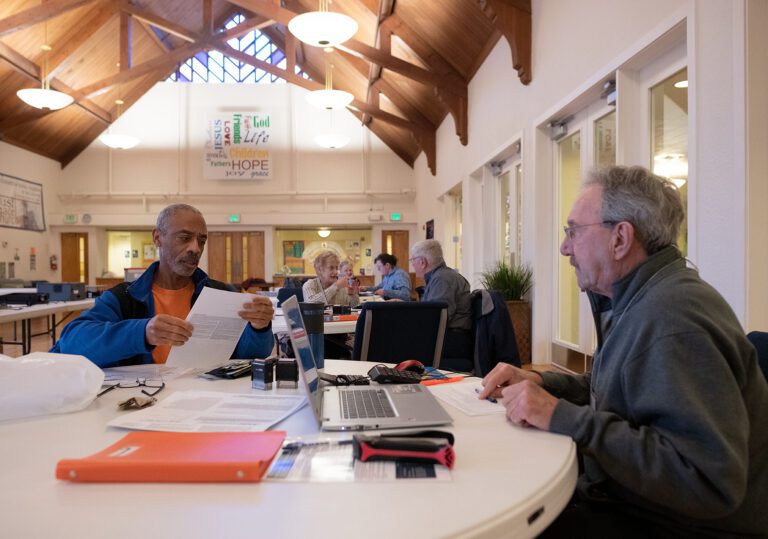 Joe Pruitt, left, looks over a document while completing his taxes with help from Alan Brown.