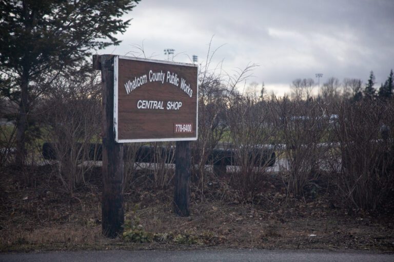 An outdoor sign for Whatcom County Public Works on the side of the road.