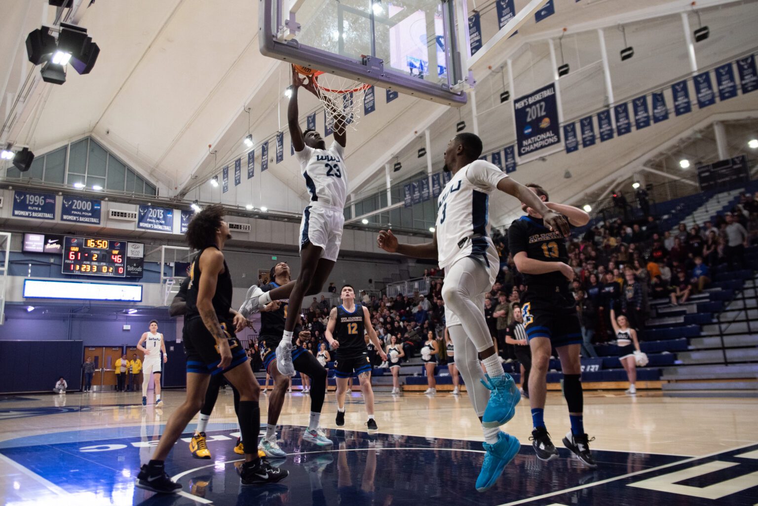 Western redshirt freshman forward BJ Kolly (23) leap to dunk the ball as he is surrounded by both team players.