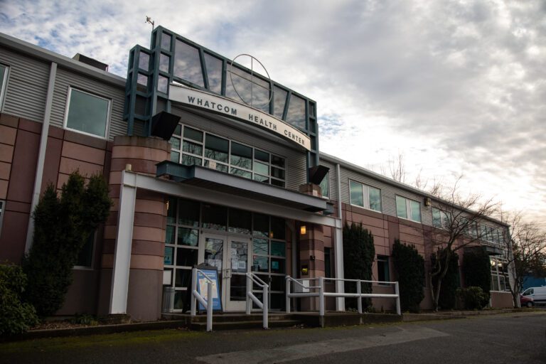 The medical examiner's office front office with clouds looming behind the building.