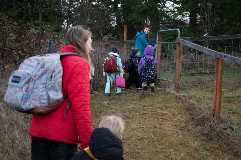 Teacher Katy Mullen leads students to their classroom at Barefeet Farm School.