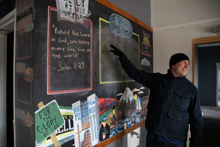 President and CEO Hans Erchinger-Davis points to a chalkboard wall for guests' goals.