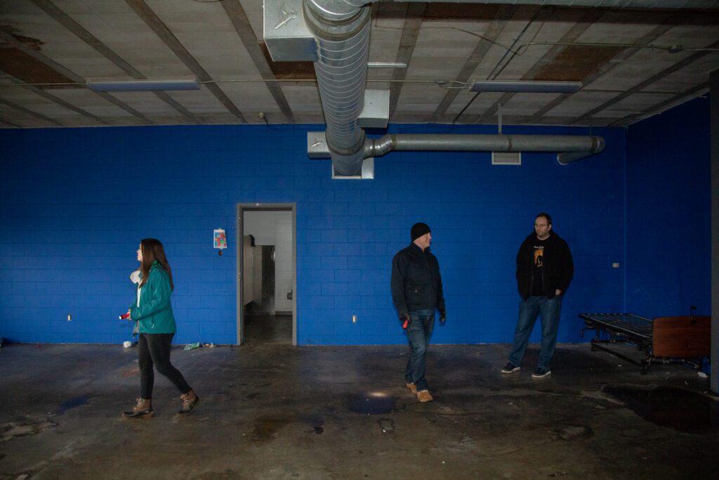 Emily Martens, CEO Hans Erchinger-Davis and Jamie Severson roam the former blue emergency shelter on the third floor of the building.