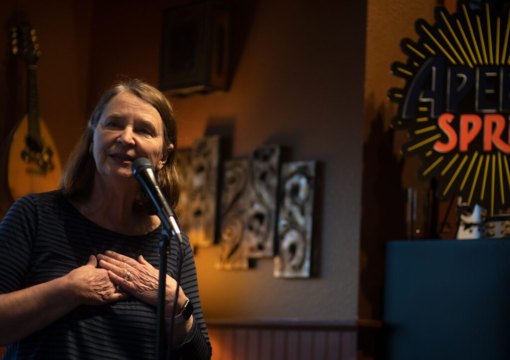 June Thompson performs with Jim DeBari with her hands together.