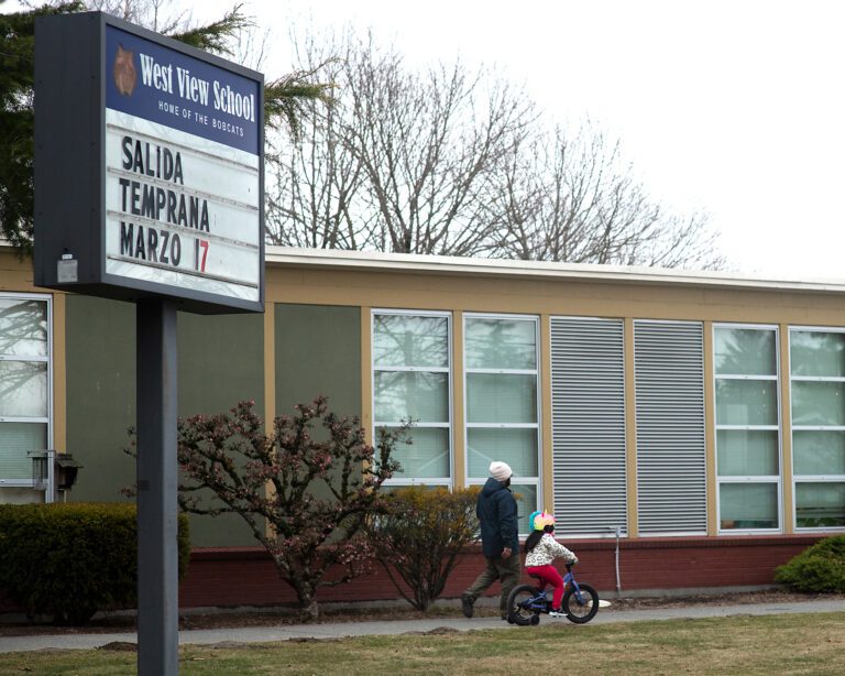 West View School has an outdoor sign as a parent and their child walks past.