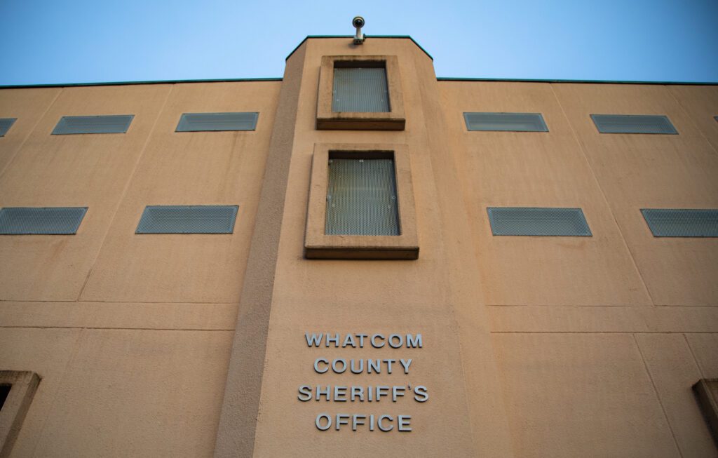 "Whatcom County Sheriff's Office" is listed on the side of an orange building.