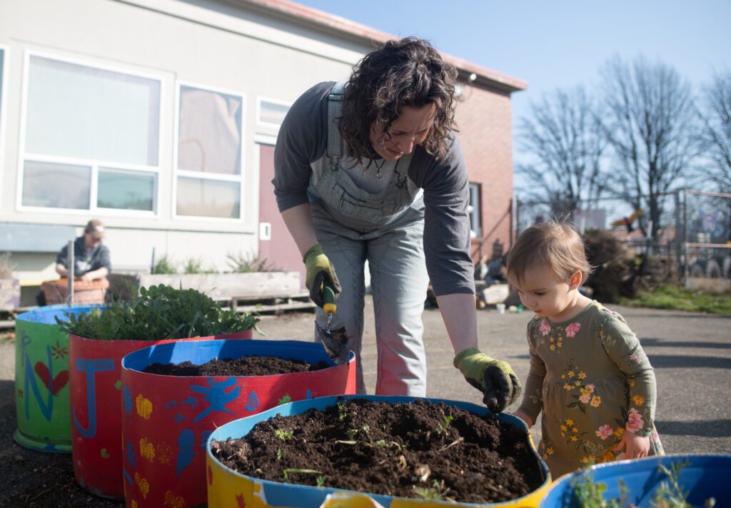 Julie Hiett shows her daughter, Lucy, how to garden.