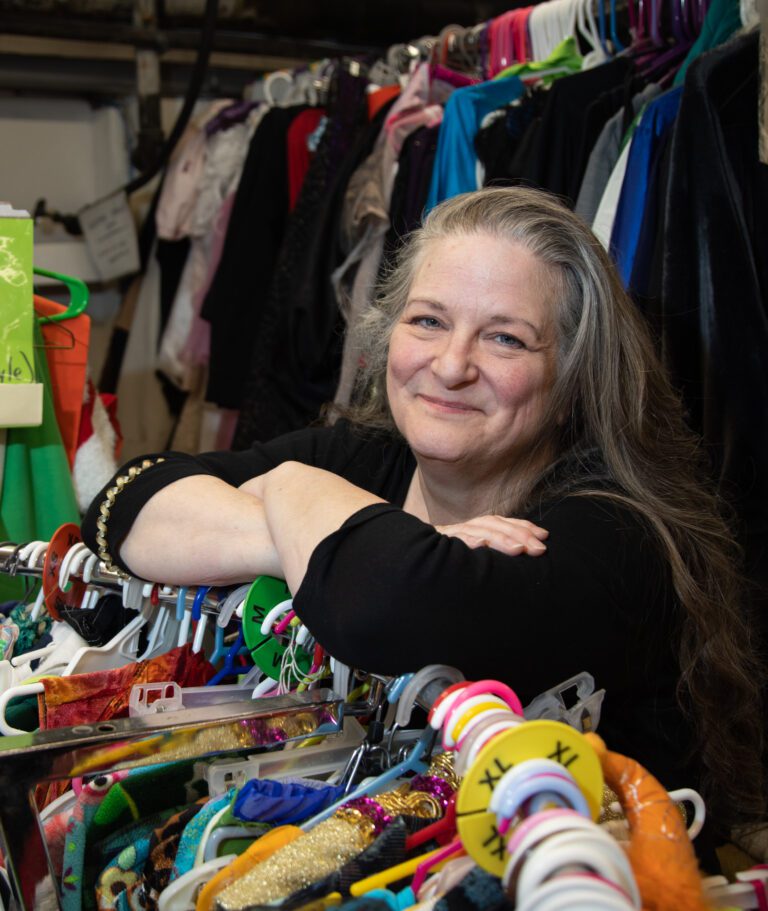 Dana Crediford stands in the crammed-to-the-gills costume shop with her elbows on the racks.