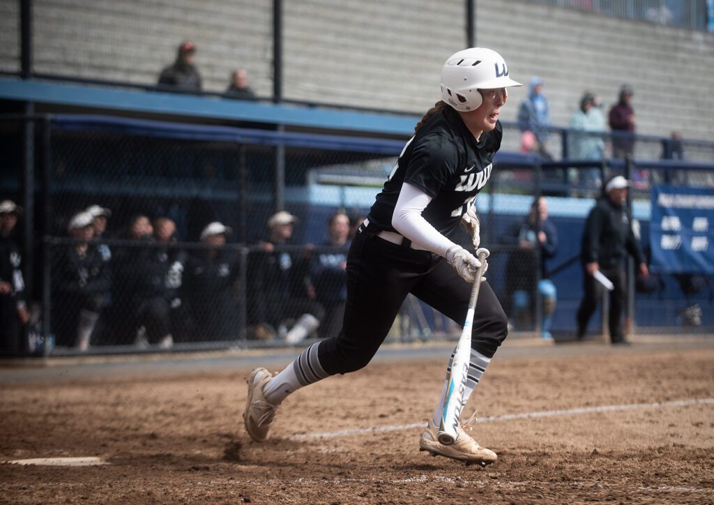 Western junior catcher Emily Paulson drops her bat as she takes off from the plate.