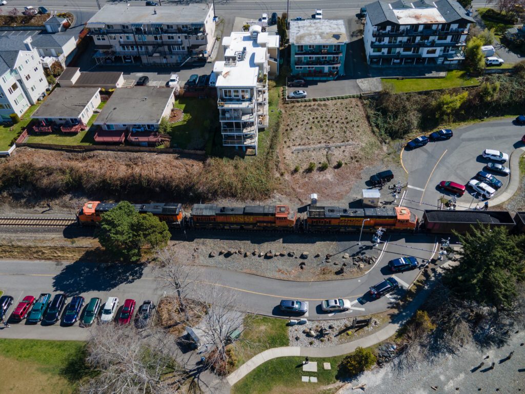 The BNSF coal train blocks the road into Boulevard Park next to residential buildings.