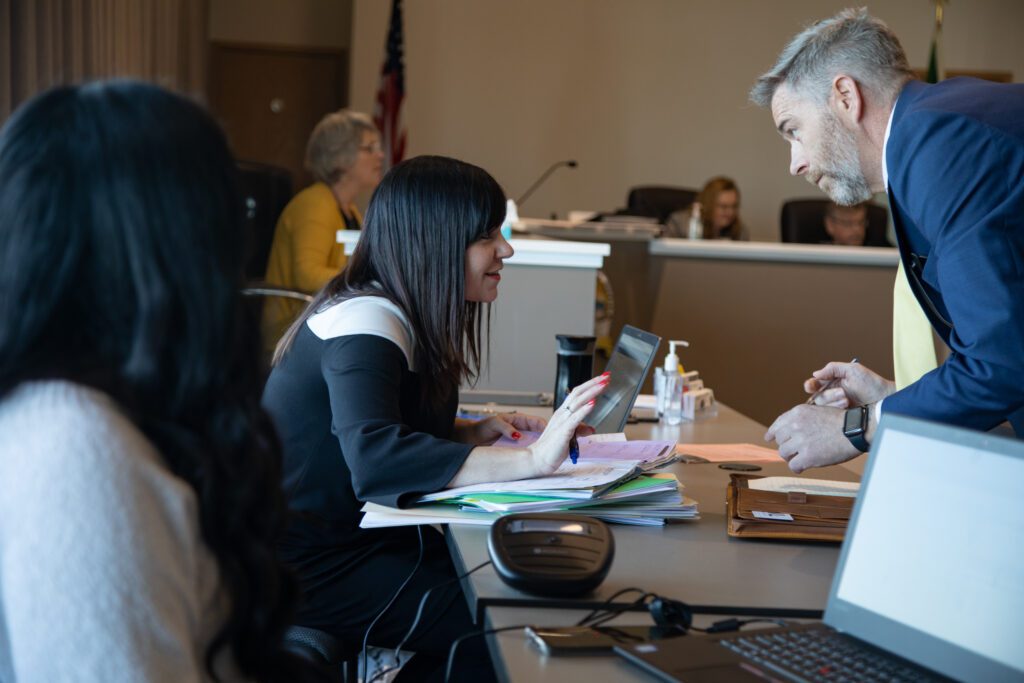 Probation officer Makenzie Foster, center, speaks with an attorney during court.