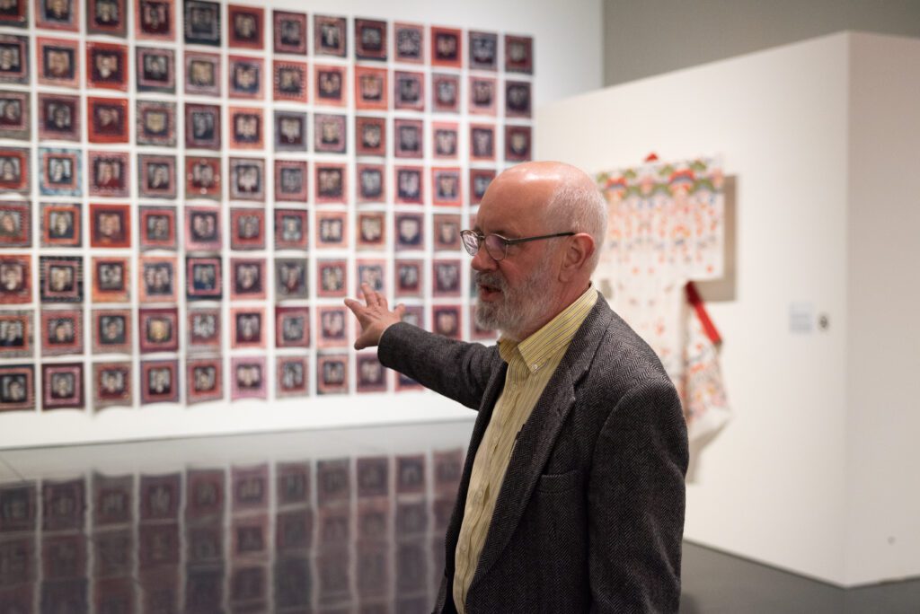 Paul Brower gestures to Cheryl Lawrence's "Women of the 116th Congress, 2019," as he talks.