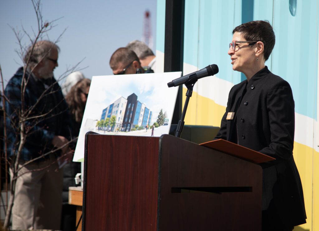 Mauri Ingram, president and CEO of the Whatcom Community Foundation delivers a speech from behind a wooden podium.