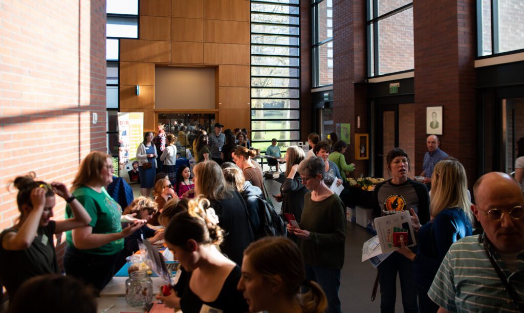 Attendees visit booths and panels as they chat amongst the crowd as they wait their turn.