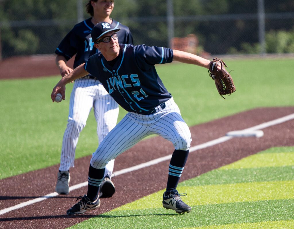 Lynden Christian senior pitcher Isaac Paxton pulls back his arm to pitch the ball as a teammate watches from behind him.