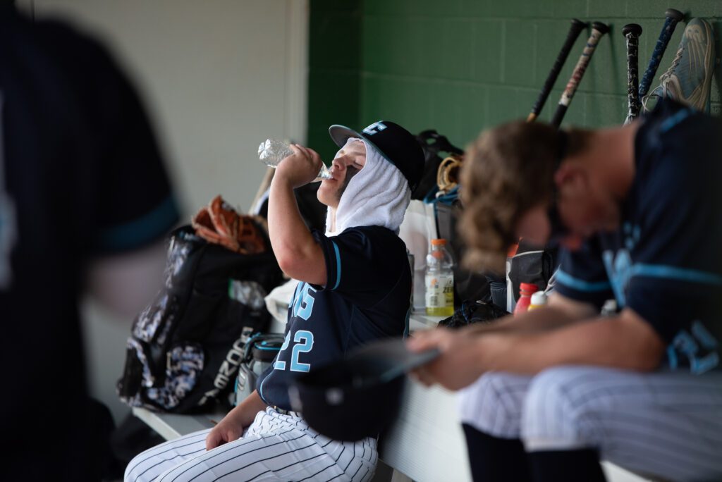 Lynden Christian sophomore second baseman Austin Engels drinks water with a towel wrapped around his head.