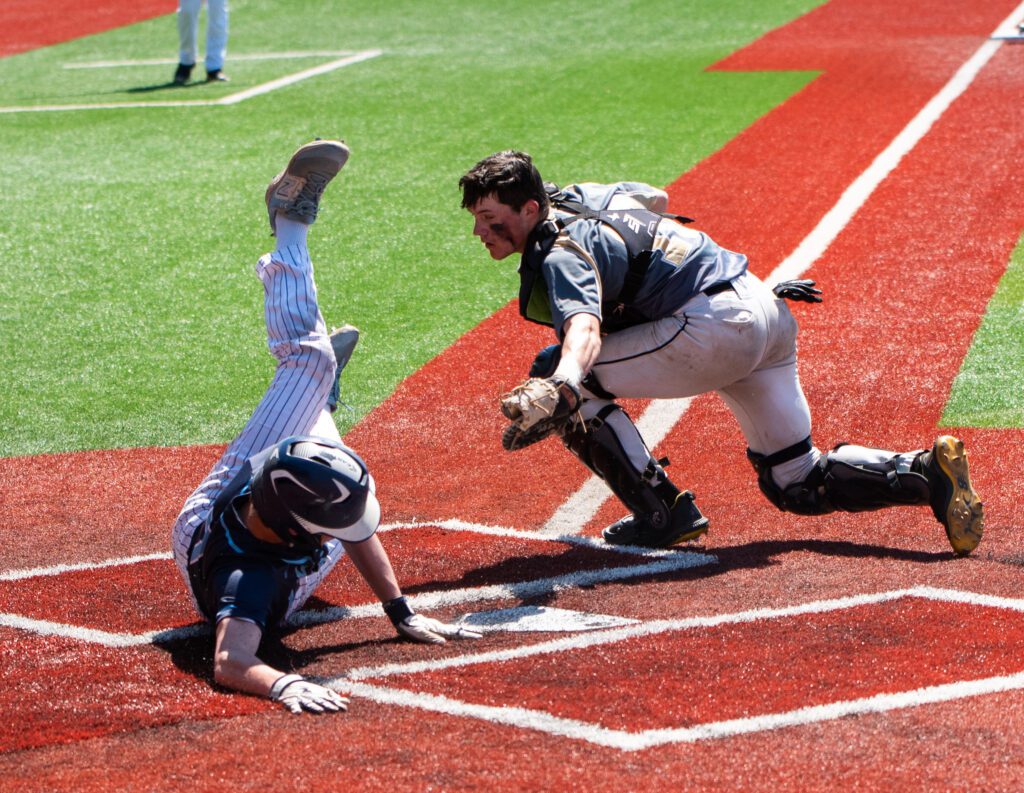 Lynden Christian junior shortstop Jonah Terpstra avoids the tag by diving for the home plate.