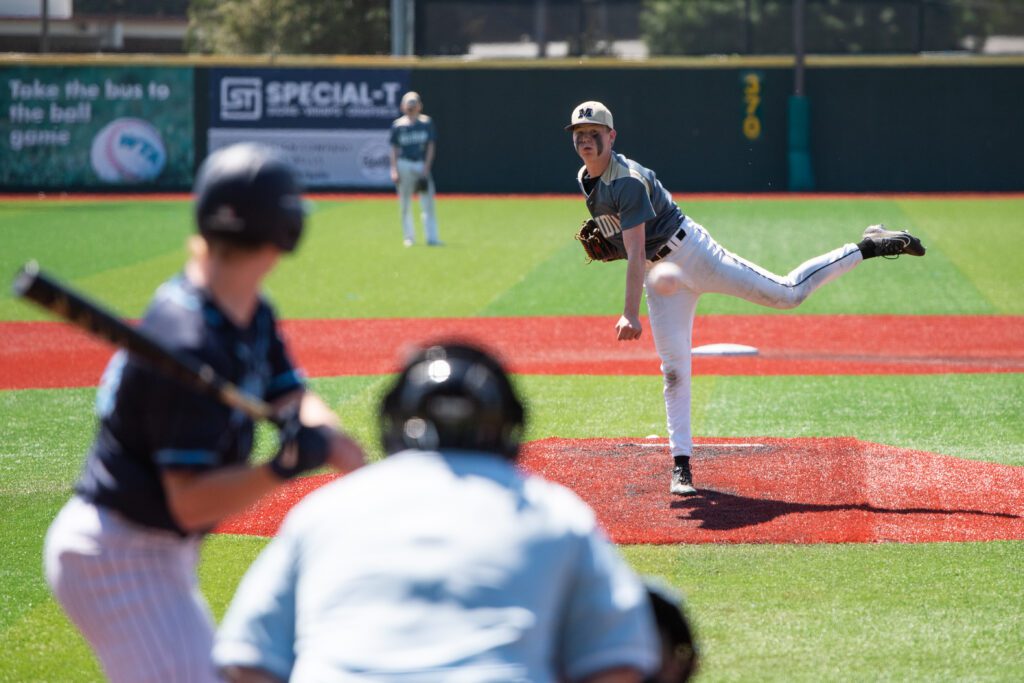 Meridian sophomore pitcher Jonah Aase lifts a leg as he pitches the ball.