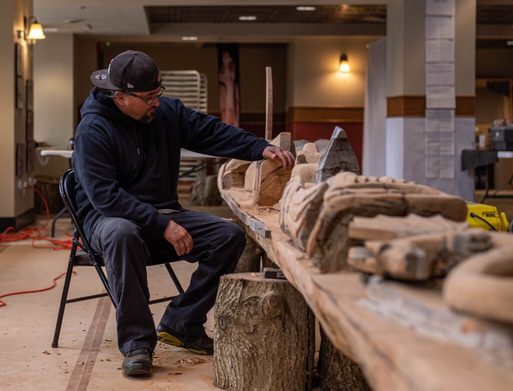 Jason LaClair sits as he examines his first wood carving project.