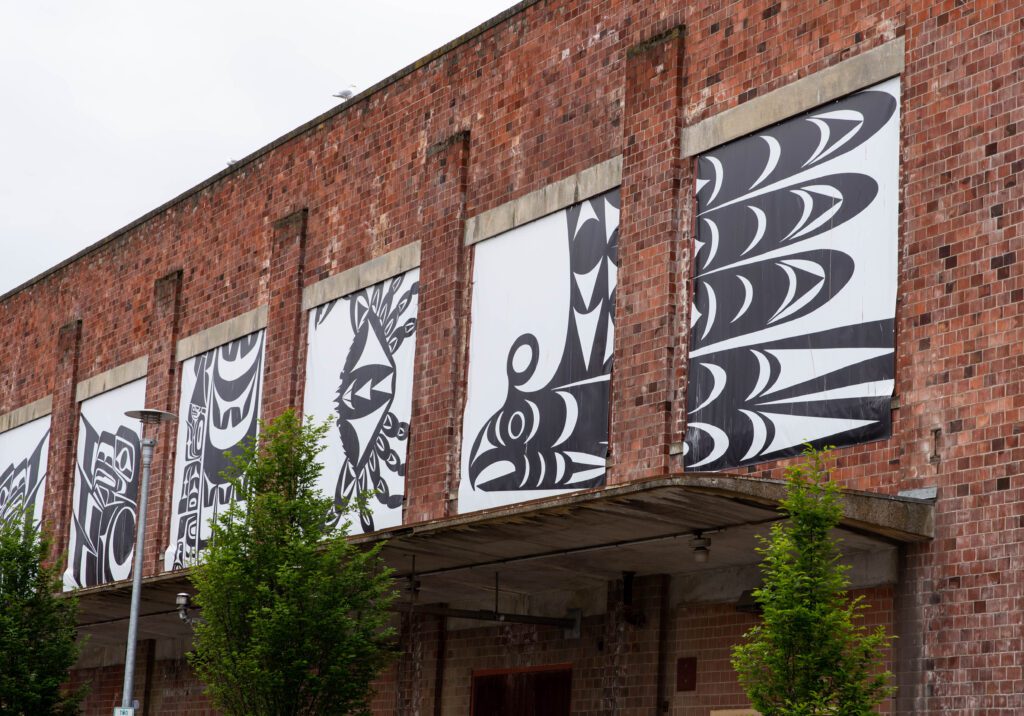 "Honoring the Salish Sea," a collaborative project of Jason LaClair and three other artists, has black and white tribal banners hang from the Boardmill building.