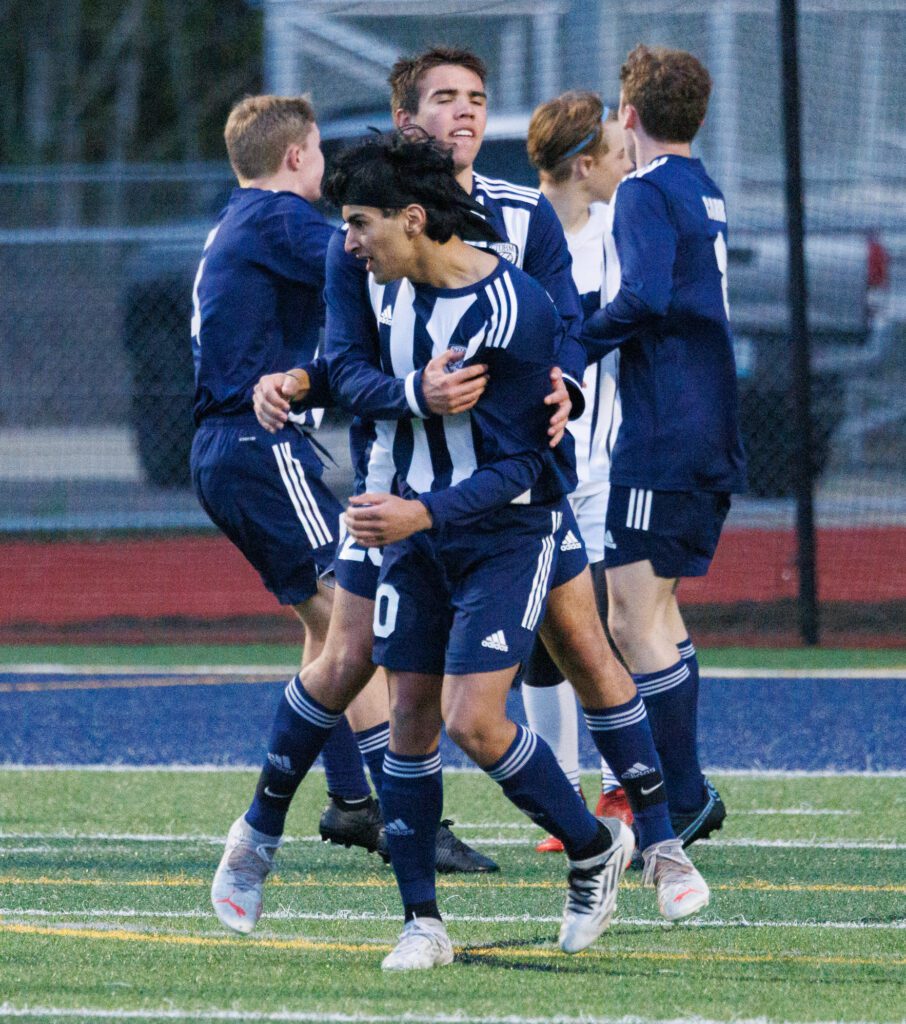 Squalicum's Gurparam Singh, center, is hugged by teammates.