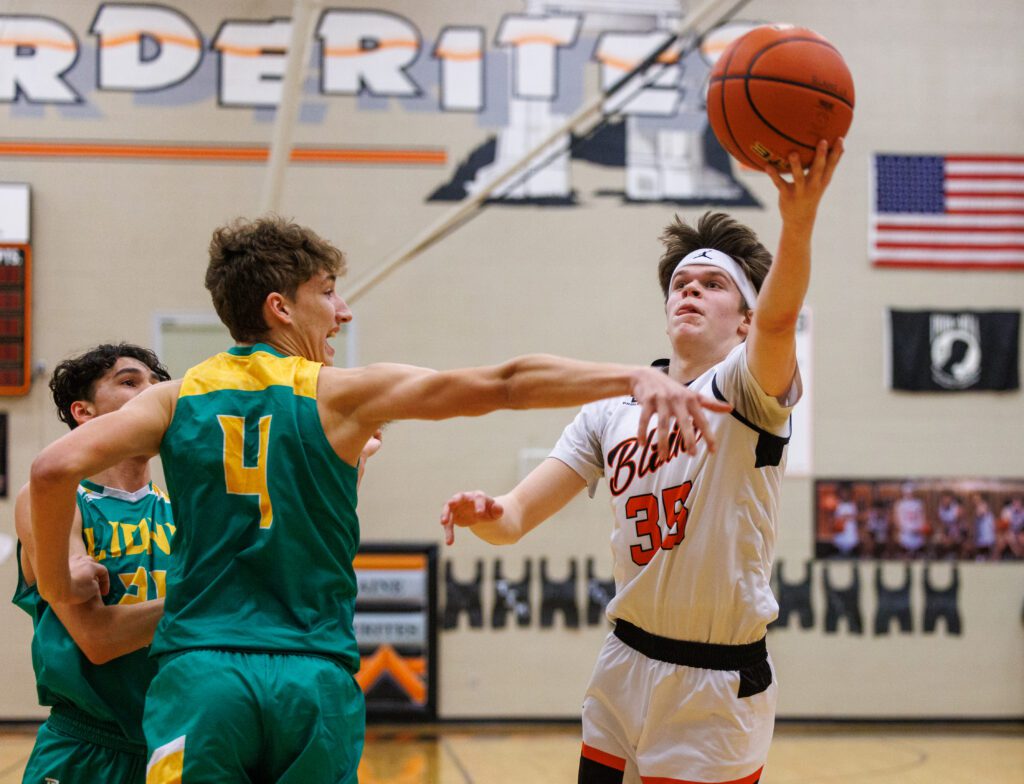 Blaine’s Carson Lehnert throws up a shot around Lynden’s Cameron Petersen as both defenders collide accidentally.