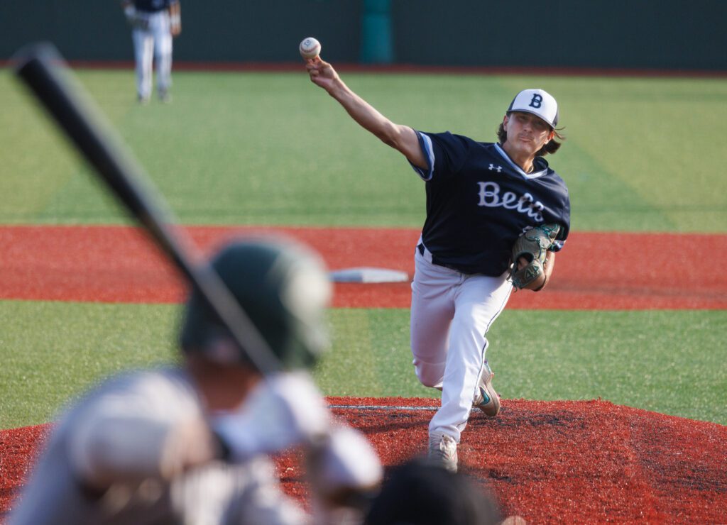 Cody Delvecchio delivers a pitch as a batter gets ready.