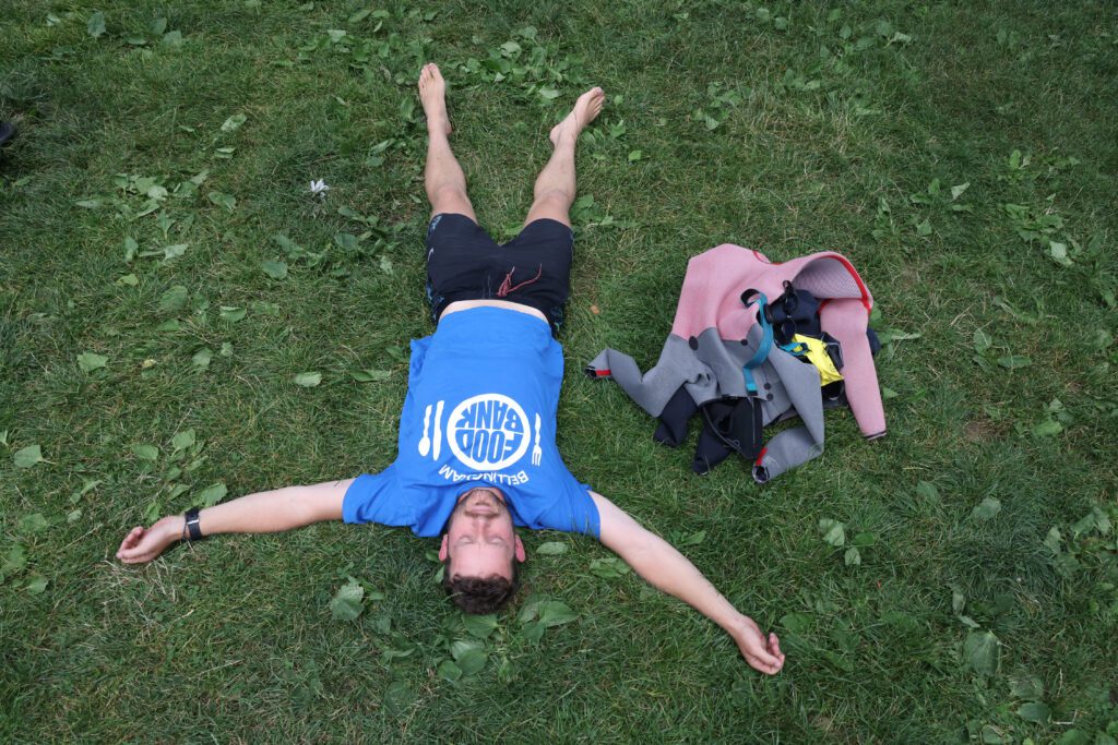 Ethan Hunger lays on the grass with his swim gear next to him.