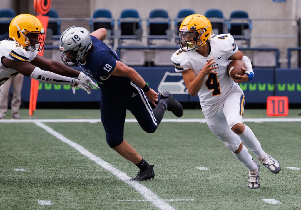 Ferndale quarterback Bishop Ootsey avoids a tackle while a defender keeps the pressure on him.